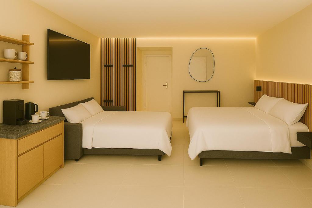 Una habitación de hotel con dos camas y un televisor. en Escala - Family Room, en Fully