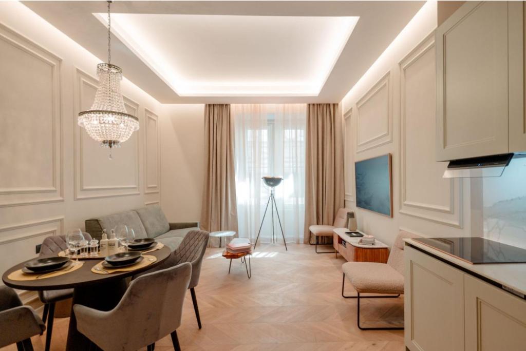a living room with a dining room table and a kitchen at Palazzo Panfilli Central Luxury in Trieste