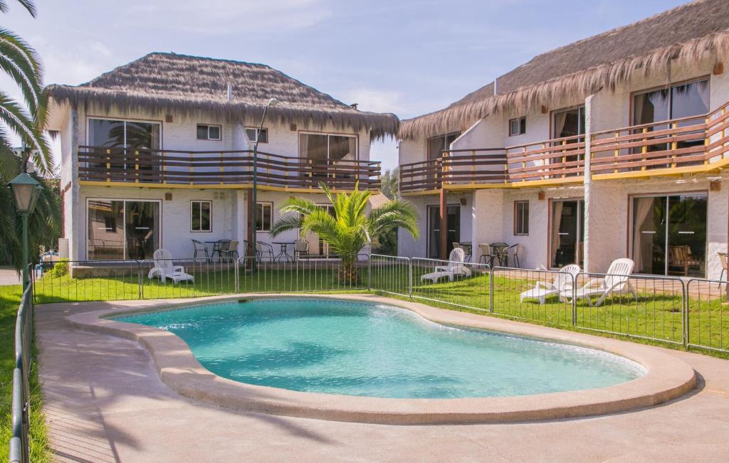 a swimming pool in front of a house at Cabañas Las Añañucas I in La Serena