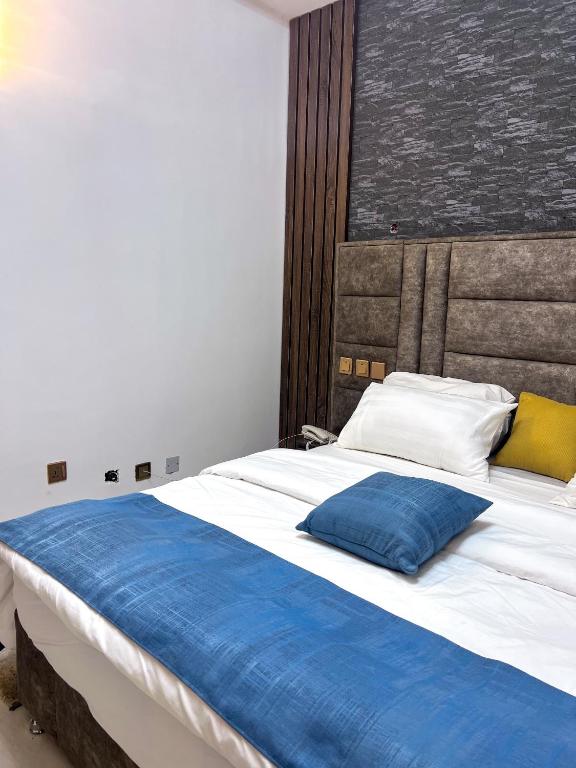 a large bed with a blue pillow on it at dreamland hotel in Abuja