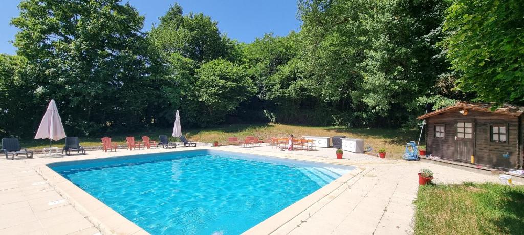 a swimming pool with chairs and a house at Gîte Réole in Reignac