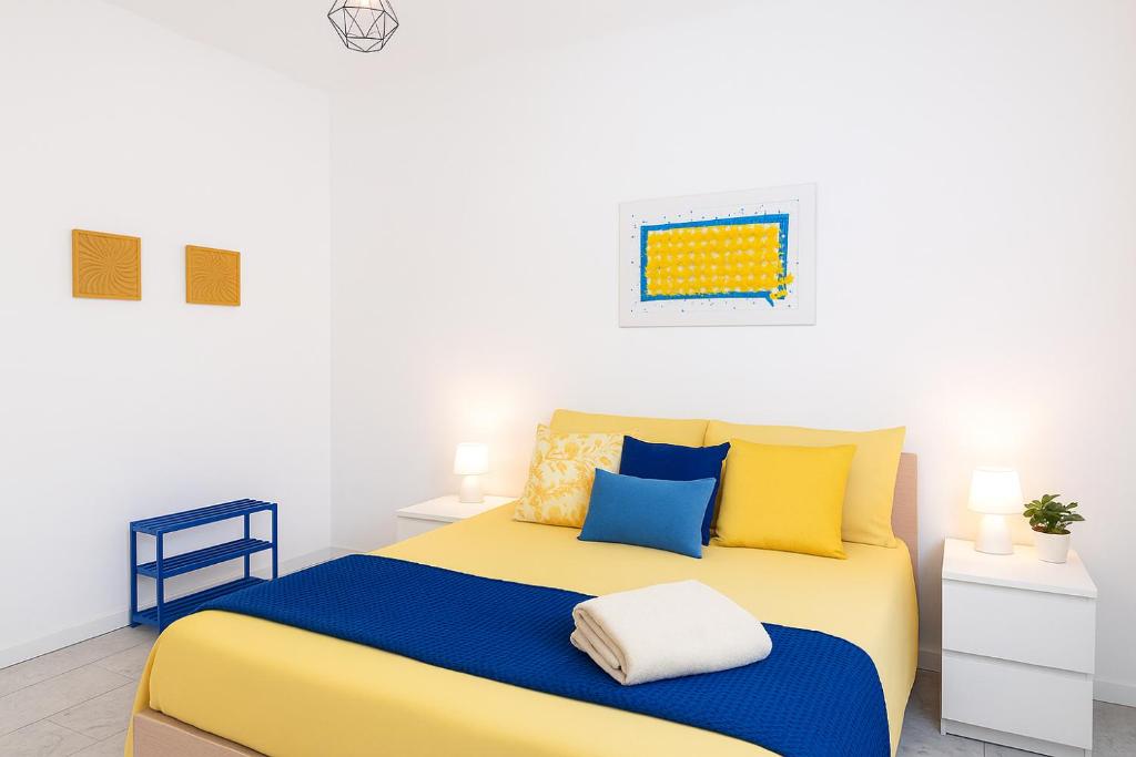 a bedroom with a bed with yellow and blue pillows at Casa cobalto vicinissima al centro by Turin House Collection in Turin