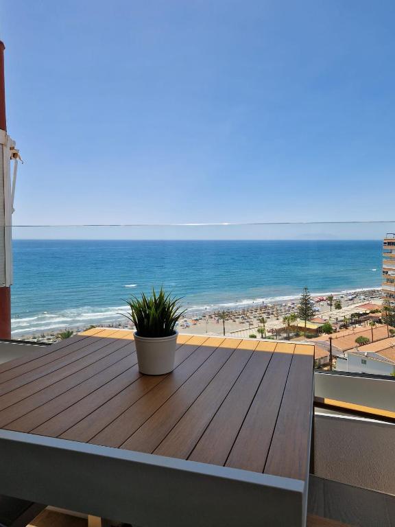 a wooden deck with a view of the beach at Apartamento Centro Internacional Torrox Costa in Torrox Costa