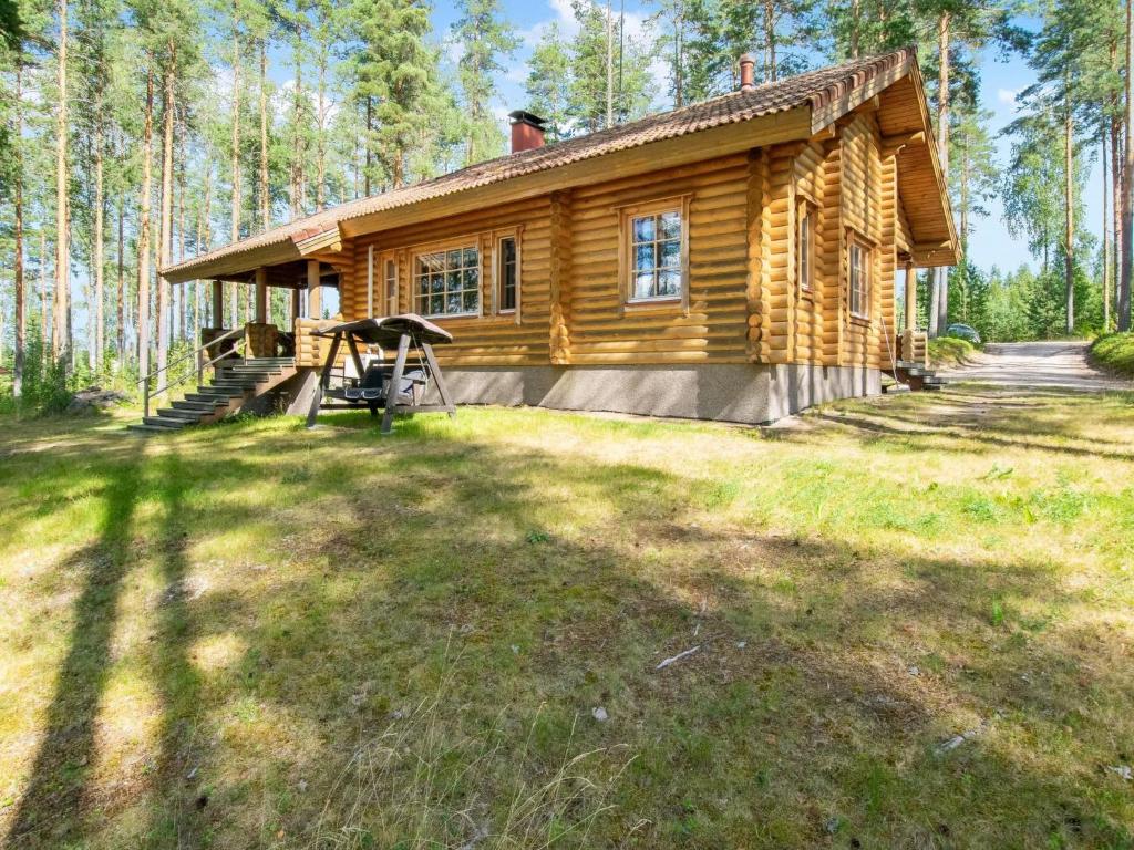 eine Blockhütte mit einem Picknicktisch davor in der Unterkunft Holiday Home Männikkö by Interhome in Kammola