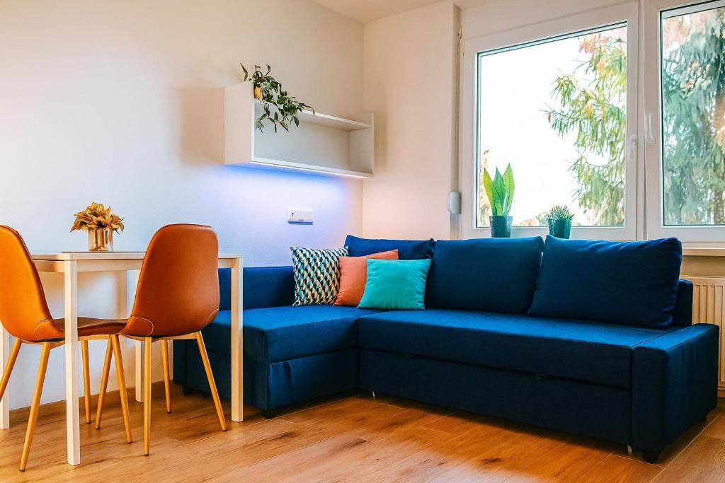 a blue couch in a living room with a table and chairs at Mini Apartman - Parking free - 5 min center in Nitra