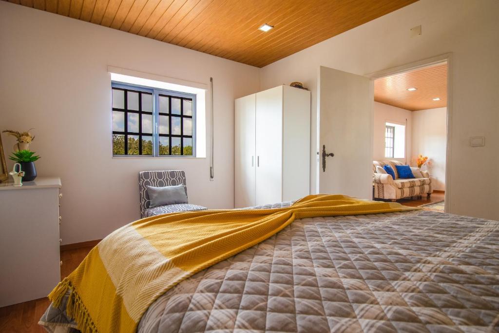 a bedroom with a large bed and a window at Quinta Ti Lita in Tocha