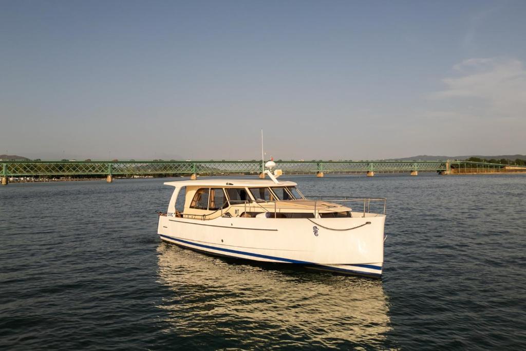 Un barco blanco en el agua cerca de un puente. en Rosé Dream Boat by Portugal Active, en Viana do Castelo
