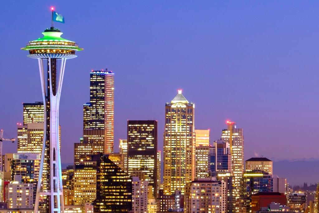 a city skyline with the space needle at night at Astra Hotel, Seattle, a Tribute Portfolio Hotel in Seattle