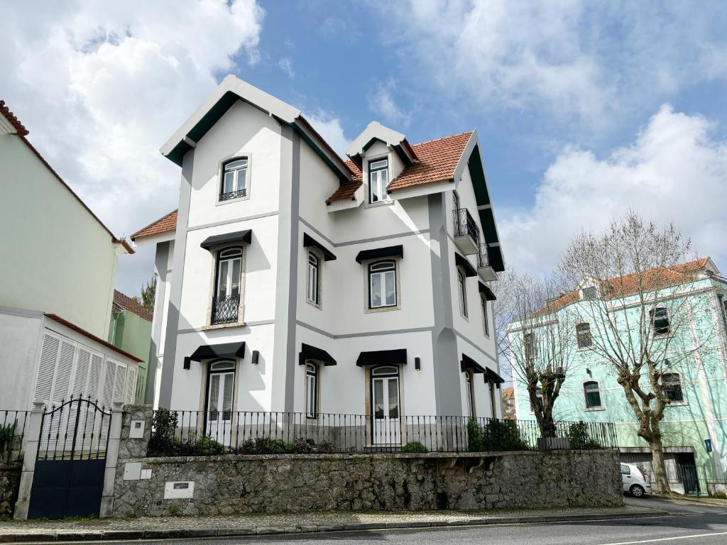 a white house with a brown roof at Live Sintra Boutique Guest House in Sintra