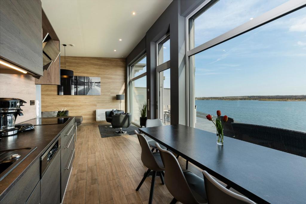 a kitchen with a table with chairs and a large window at Ferienhaus SUNSET am Mühlfeldsee in Löbnitz