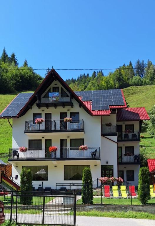 a house with solar panels on the roof at La Cascade 2 in Moieciu de Sus