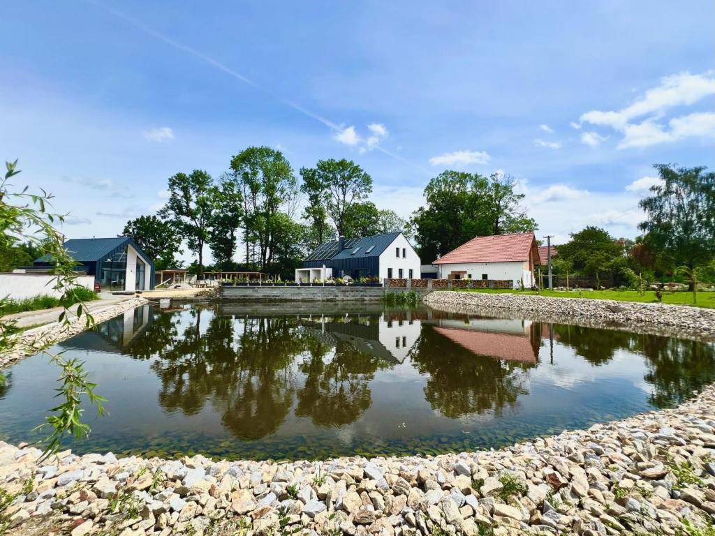 a pond with houses and trees in the background at Holiday Home Luxury Retreat Resort by Interhome 