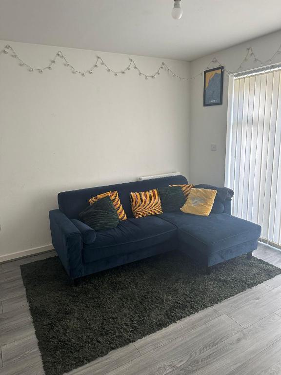 a blue couch sitting in a living room at Tyldesley Manor in Tyldesley