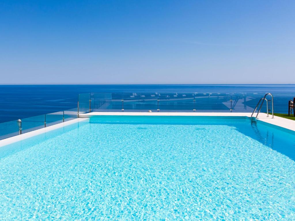 a swimming pool with the ocean in the background at Apartment Heaven Free Spa & Padel by Interhome in Torrox Costa