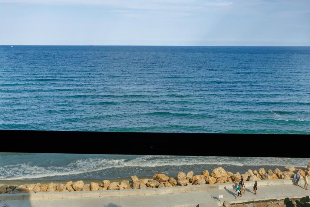 a view of the ocean with people walking on the beach at AER Apart & Wine in Eforie
