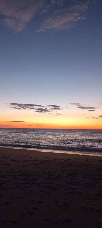 a sunset on a beach with the ocean at Casa de Férias Terra e Mar in Póvoa de Varzim