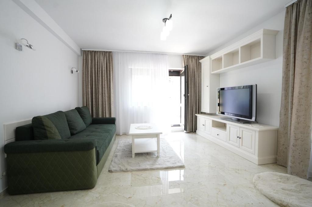 a living room with a couch and a flat screen tv at Apartament Ultracentral NICOL in Curtea de Argeş
