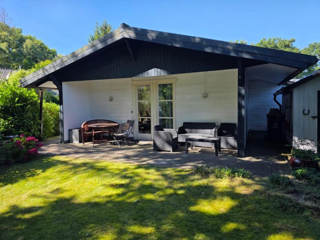 a covered patio with a table and chairs at Gundis Heidehuus, Ferienhaus in Schneverdingen