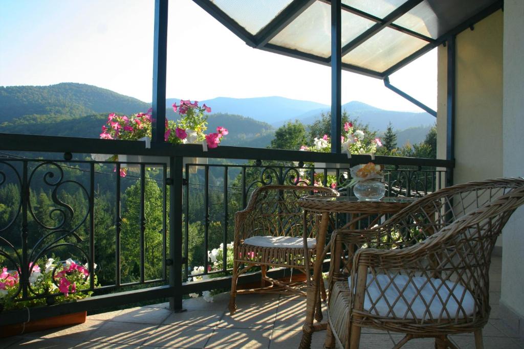 a balcony with a table and chairs and flowers at Goverla in Yaremche