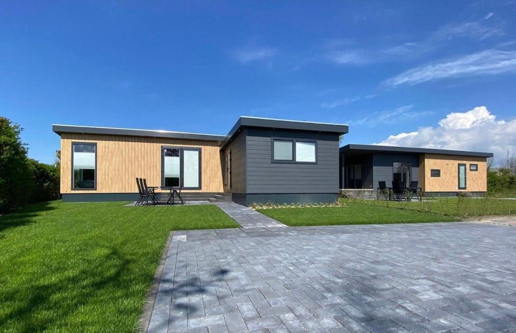 a house with a brick driveway in front of it at Vakantiepark de Zeeuwse Parel - de Schelde in Sint Maartensdijk