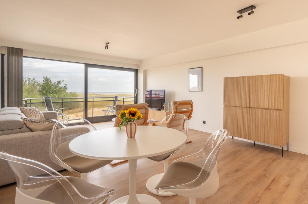 ein Wohnzimmer mit Tisch und Stühlen in der Unterkunft Appartement met 3 slaapkamers, terras en prachtig uitzicht in Knokke-Heist