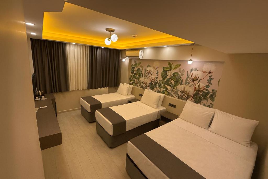 a hotel room with two beds and a couch at City Hotel İstanbul in Istanbul