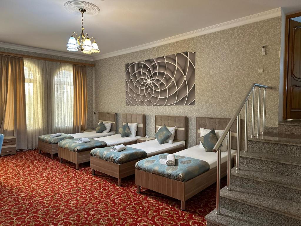 a hotel room with four beds and a staircase at SaraSofi Hotel in Baku