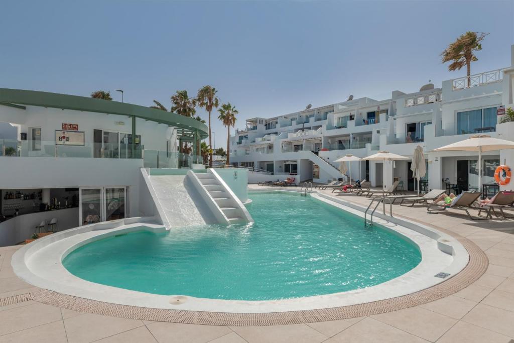 ein Schwimmbad mit Rutsche in einem Resort in der Unterkunft Estudio Kikere Puerto del Carmen in Puerto del Carmen