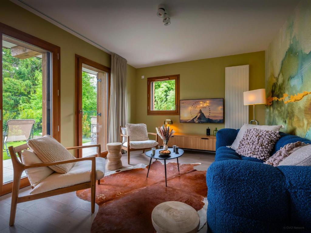 a living room with a blue couch and chairs at Lodge Sami - OVO Network in Samoëns