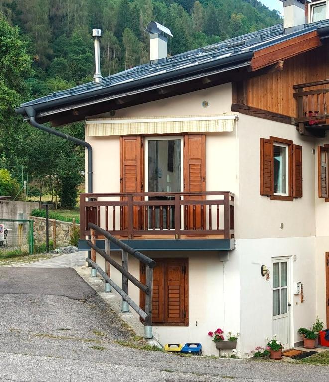 a house with a porch and a balcony at Il Terrazzino Val di Sole in Dimaro