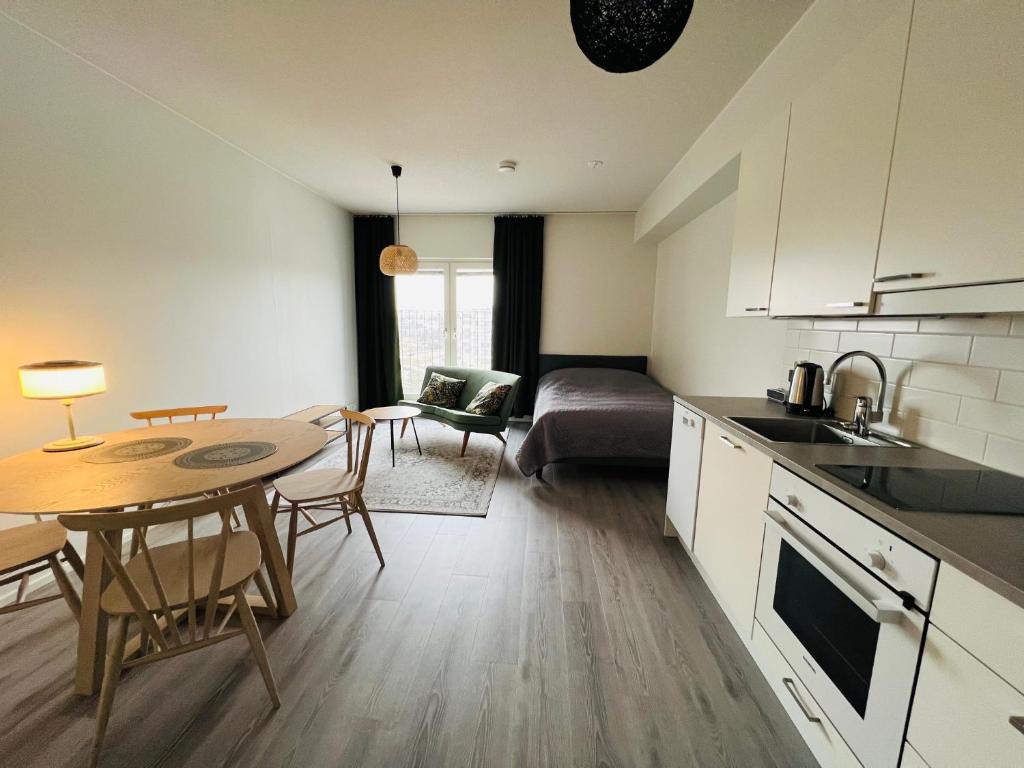 a kitchen and living room with a table and a couch at Kiva yksiö kahdelle in Turku