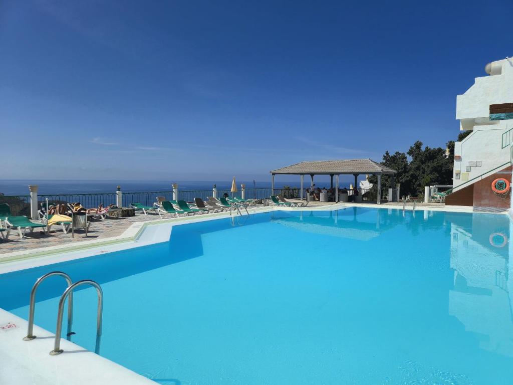 a large swimming pool with the ocean in the background at Dreams Paradise Puerto Rico in Puerto Rico de Gran Canaria