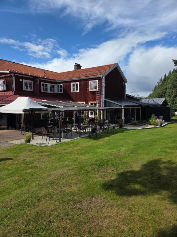a building with tables and chairs in a yard at Sjugare Gård Bed & Breakfast in Leksand