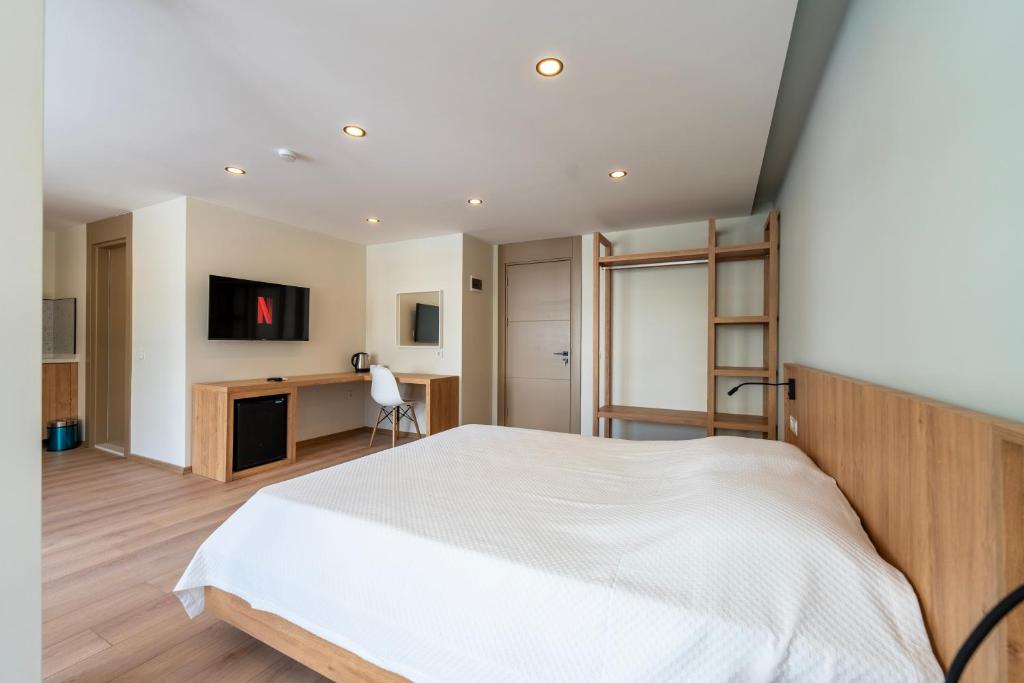 a bedroom with a white bed and a desk at Bun'ca Rooms in Antalya