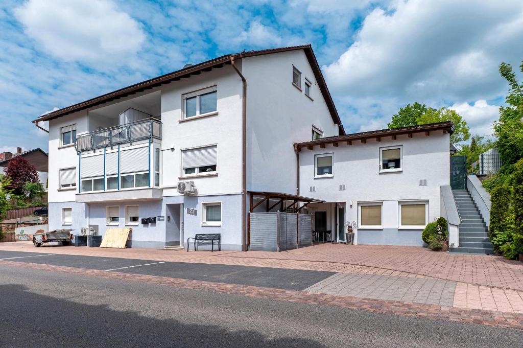 a white building on the side of a street at Ferienwohnungen Golsong in Thaleischweiler-Fröschen