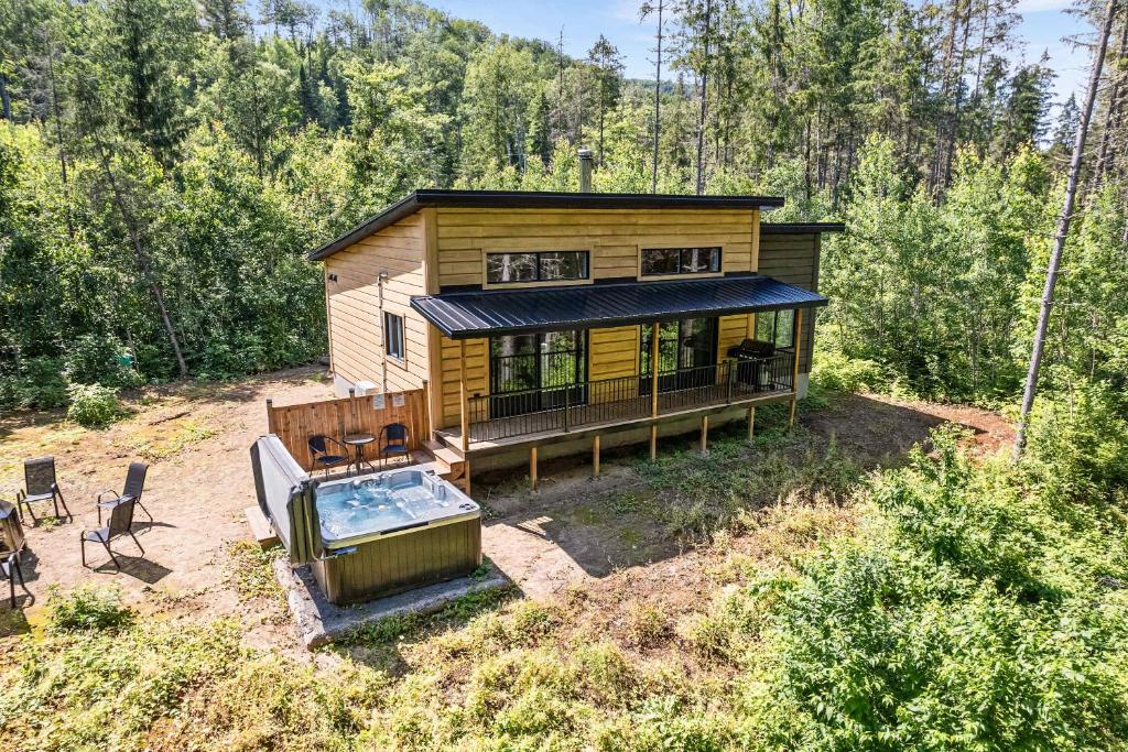a house with a swimming pool in the woods at Spa Nature & Riverside Escape - Ecureuil Roux in Trois Rives