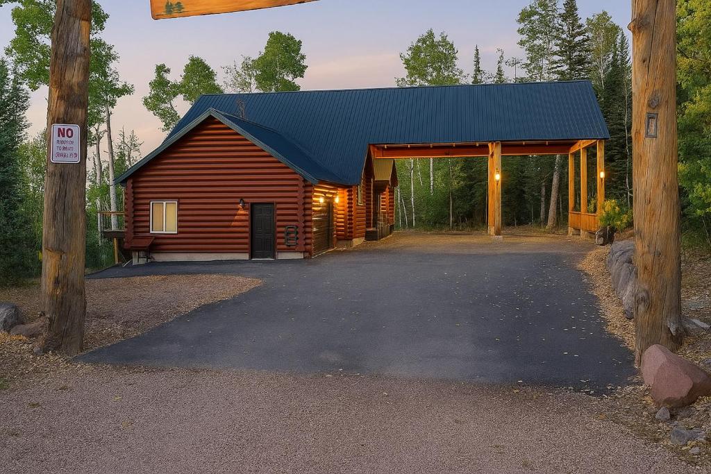 ein Blockhaus mit blauem Dach und einer Garage in der Unterkunft Hot Tub, Game Room! 3-Story Brian Head Home in Brian Head