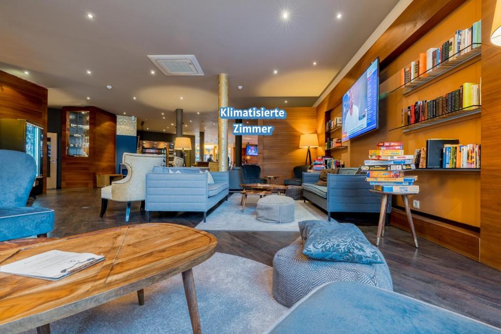 una tienda con sillas y mesas azules en una habitación en Hotel Bacchus, en Bensheim