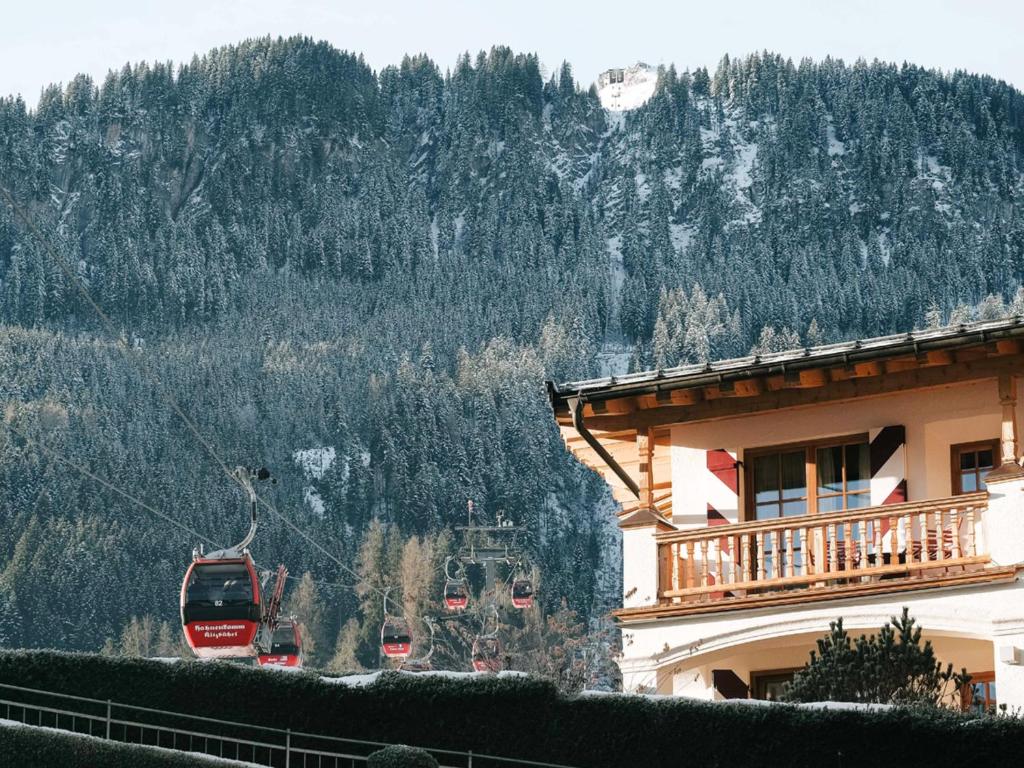a ski lift in front of a building with a mountain at Hotel Kaiserhof Kitzbühel, 4 Sterne Superior in Kitzbühel