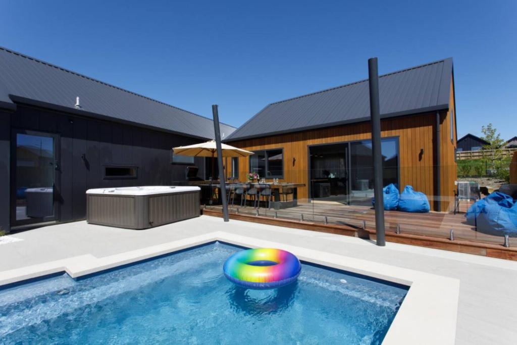 a pool with a ball in the middle of a house at Prowess Lodge luxury accommodation with private pool and spa in Wanaka