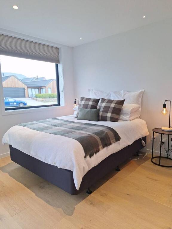 a bedroom with a large bed and a large window at Alpine Hideaway Studio in Wanaka
