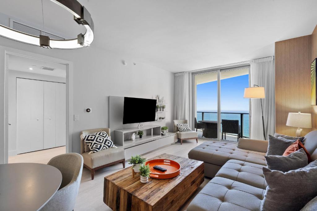 una sala de estar con un sofá y una mesa en Picturesque Beachfront Condo - LOVELY 2BD and 2BA APT WITH DIRECT OCEAN VIEW, en Hollywood