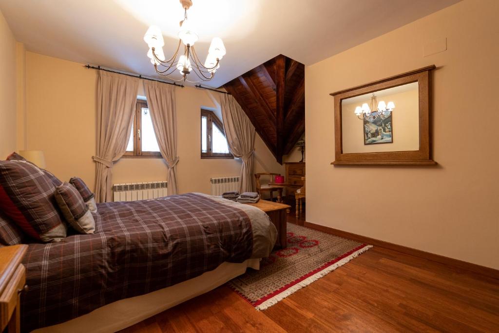 une chambre avec un lit et un lustre dans l'établissement Casa Rústica - Sorieus Lodge en Lérida, à Bossost