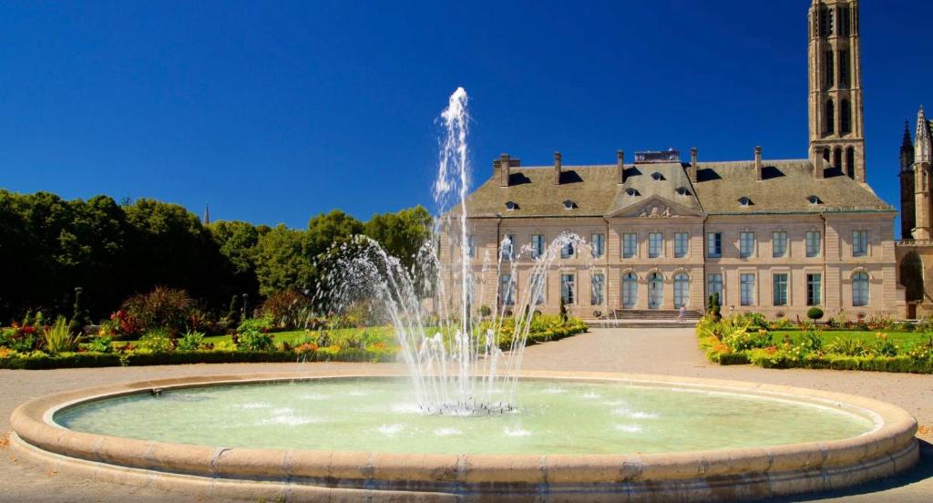 a fountain in front of a large building at Le Pent House Limoges in Limoges