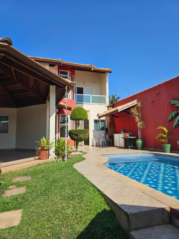 a backyard with a swimming pool and a house at Relaxe num sobrado com piscina in Peruíbe
