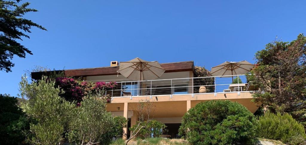 - un bâtiment avec un balcon doté de parasols dans l'établissement Villa 5 rooms with pool near the sea, à Hyères