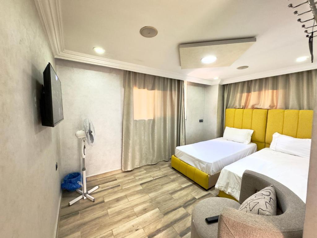 a hotel room with two beds and a tv at Maison Duplex in Sale