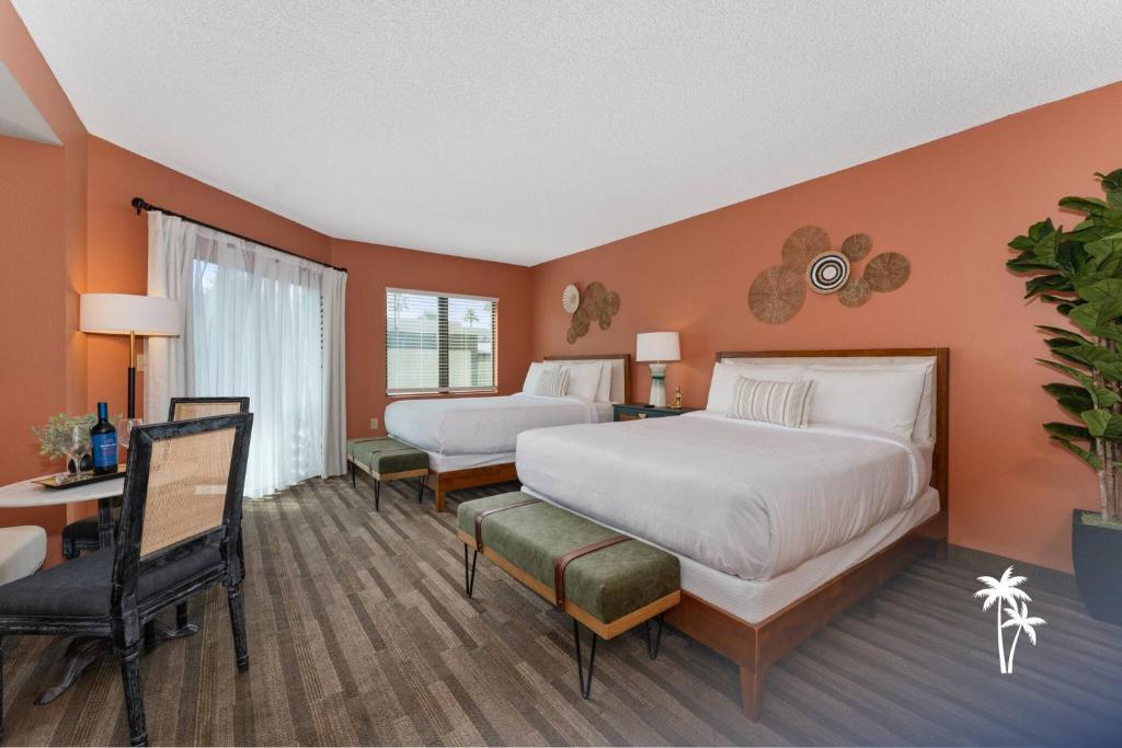 a hotel room with two beds and a desk and a chair at Boho Chic Garden Condo 7 Min to Universal Parks in Orlando