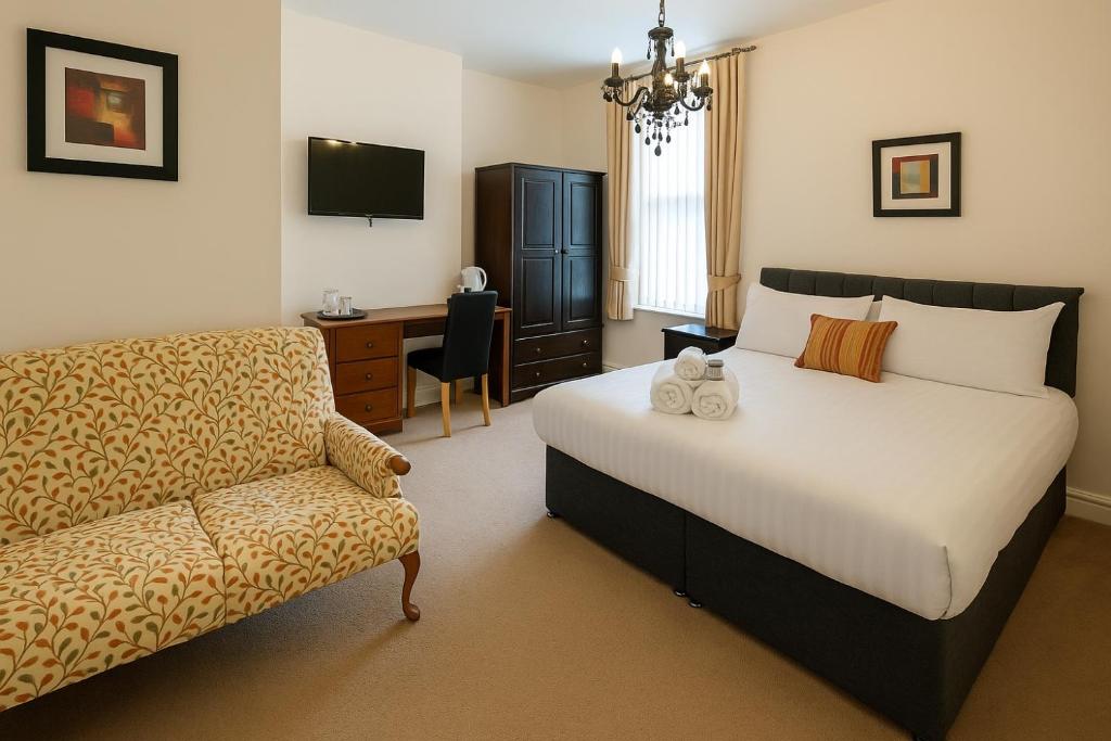 una camera da letto con un letto, una sedia e una scrivania di The Senarth Guesthouse - Seaside Guesthouse with Breakfast & Free Parking a Llandudno