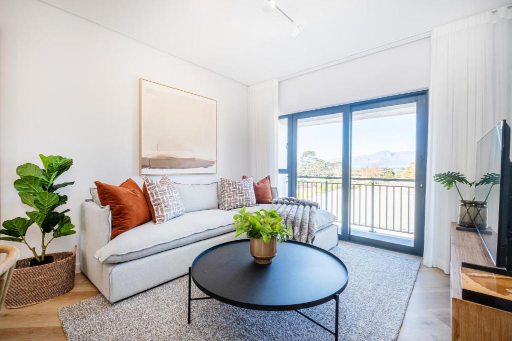 una sala de estar con un sofá y una mesa en Paarl 225 - Lux Modern 2 Bedroom Apartment with Parking, en Paarl